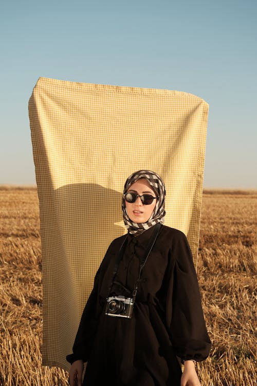 Woman in Hijab and Sunglasses on Rural Field