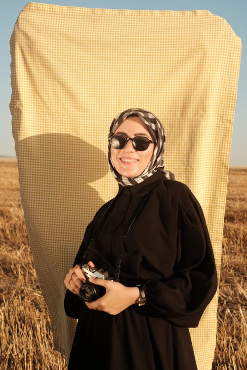 Smiling Woman in Sunglasses and Black Clothes