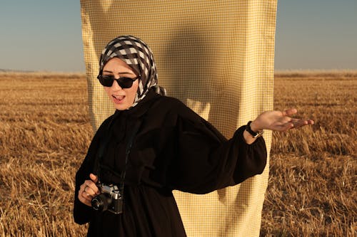 Woman in Hijab and with Camera on Field