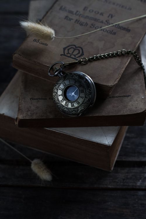 Free Elegant vintage pocket watch resting on stacked old books, perfect for timeless themes. Stock Photo