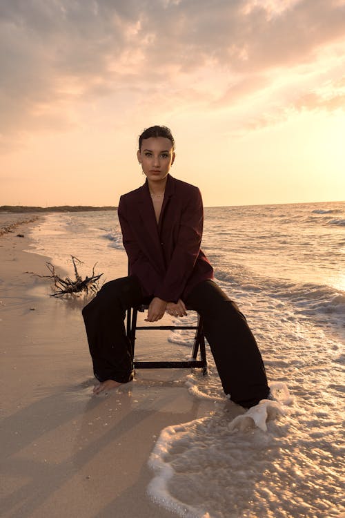 Woman Posing on Chair on Beach at Sunset