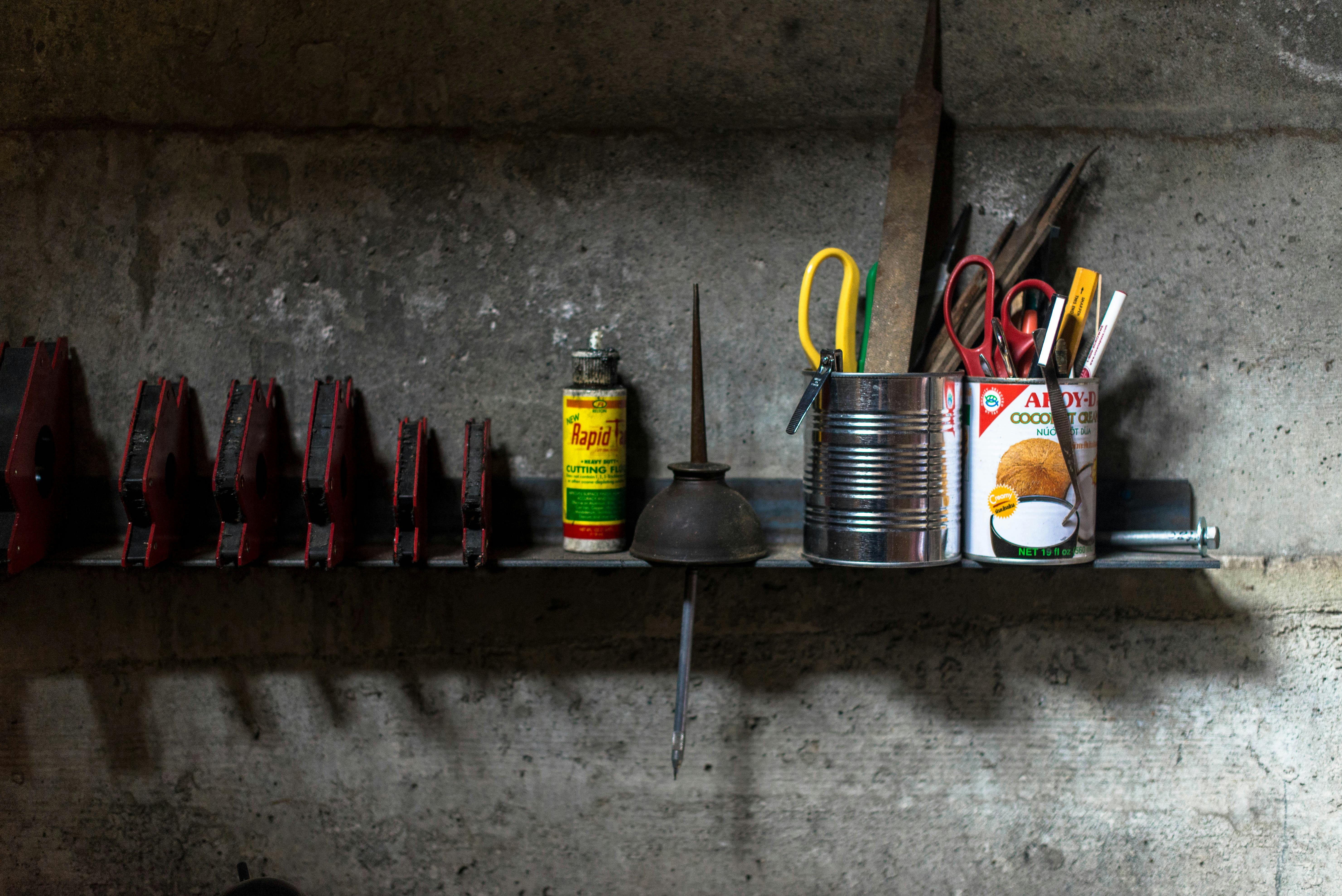 Assorted-color Scissors and Pens in Tin Cans on Brown Wooden Wall Shelf