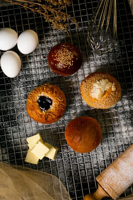 Elegant food photography showcasing freshly baked buns, eggs, and butter from a top view.