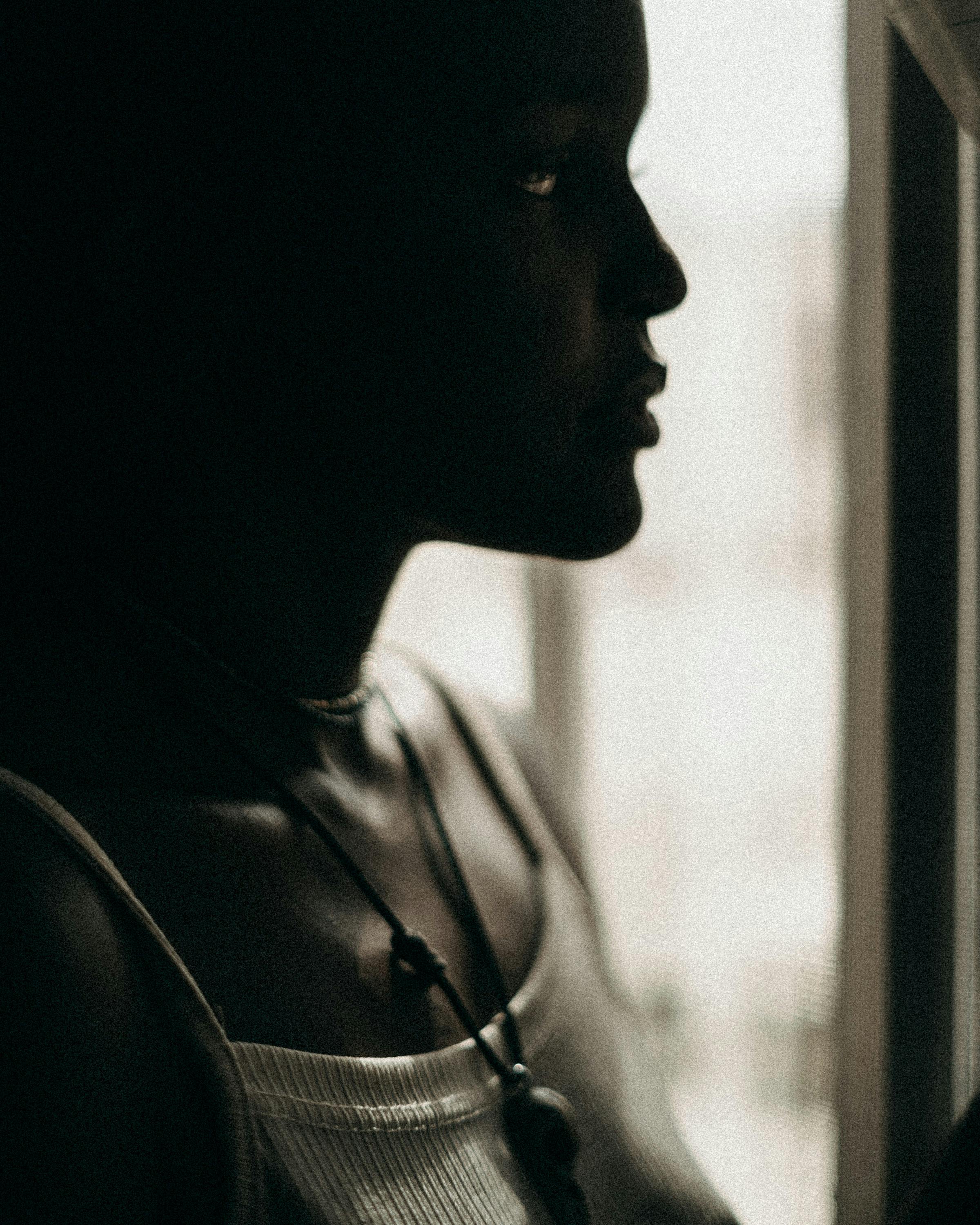 Moody portrait of a woman in natural light exploring shadow and contours.