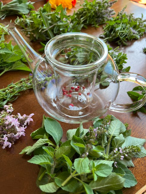 A modern kitchen counter with a glass teapot brewing herbal tea, surrounded by fresh herbs and wellness gadgets