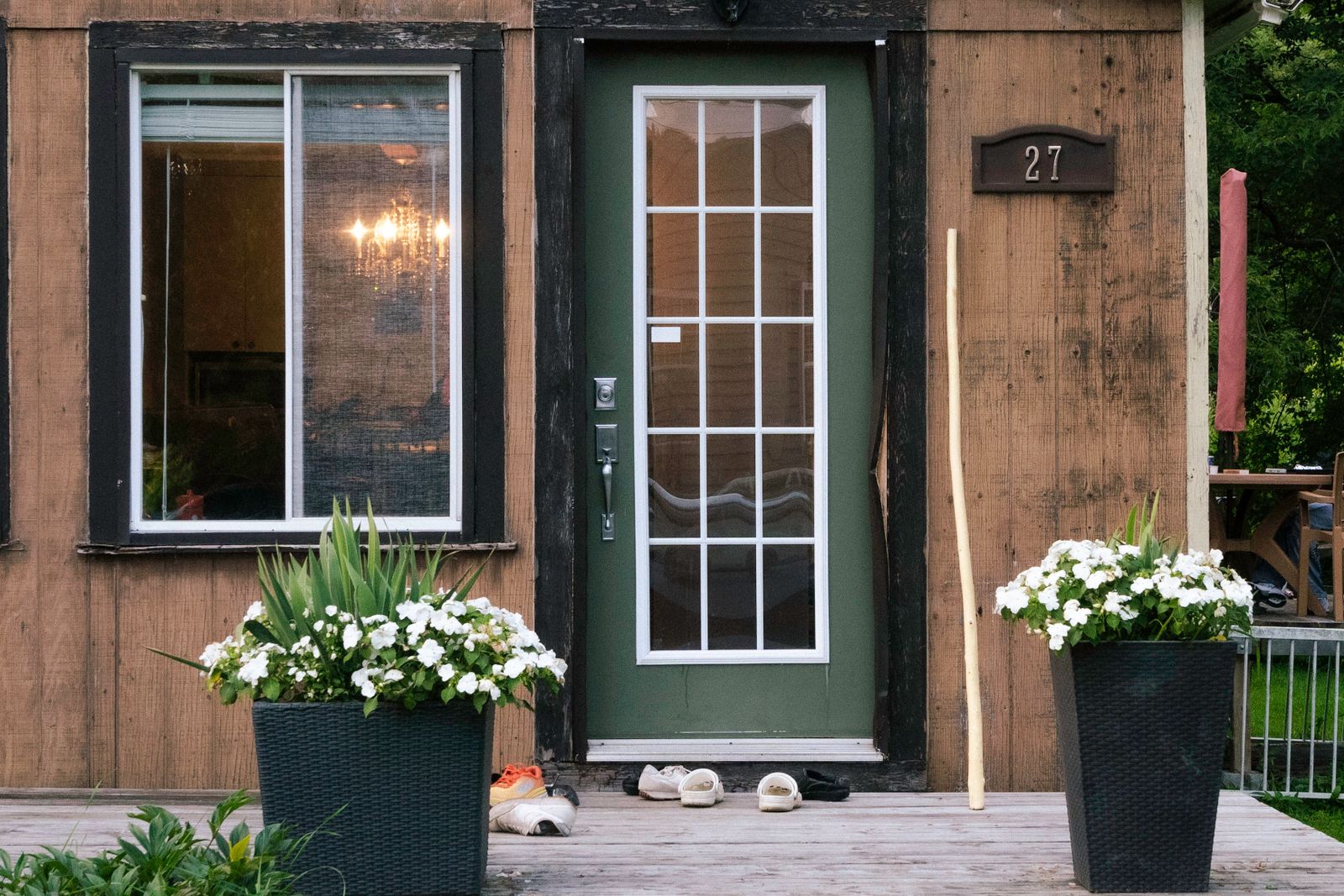 A charming rustic wooden house entrance with large potted flowers and inviting decor — thanksgiving front door decor ideas