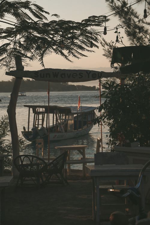 Free Peaceful sunset scene with a boat at a harbor in Lombok, Indonesia. Stock Photo