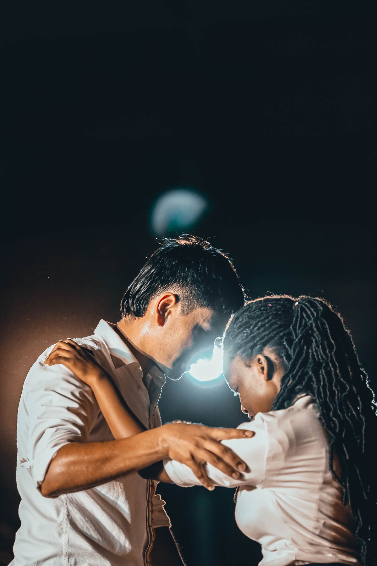 Casal a dançar kizomba sob luz quente