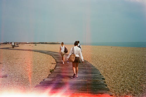 People Walking on Wooden Footpath on Beach