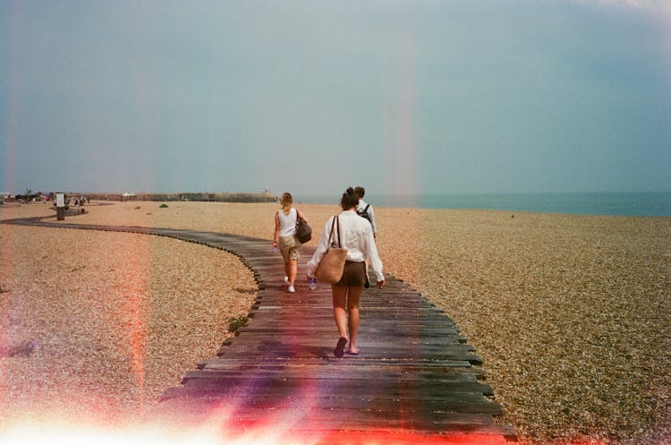 People Walking On Wooden Footpath On Beach