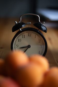 Vintage alarm clock positioned on a wooden table, offering a timeless feel.