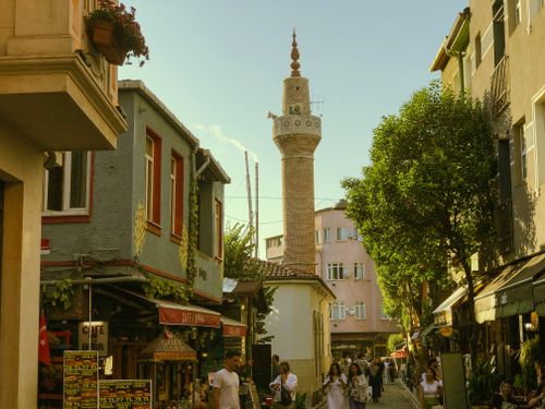 Free Vibrant street scene in Istanbul showcasing a historic minaret, shops, and people. Stock Photo