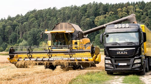 Harvester and Truck on Field