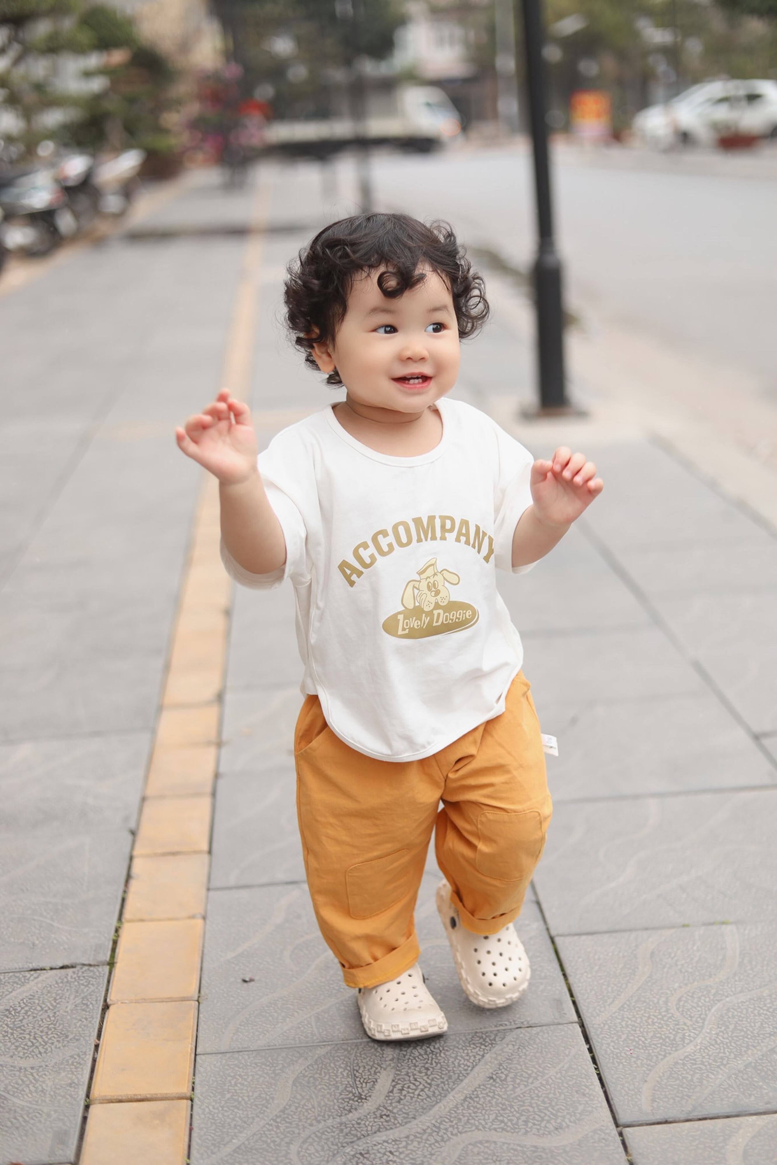 Adorable bébé marchant joyeusement sur un trottoir