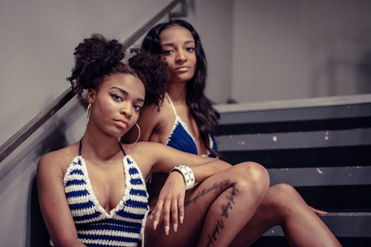 一幅别致而时尚的肖像画中，两名身穿时尚针织上衣的女性坐在楼梯上