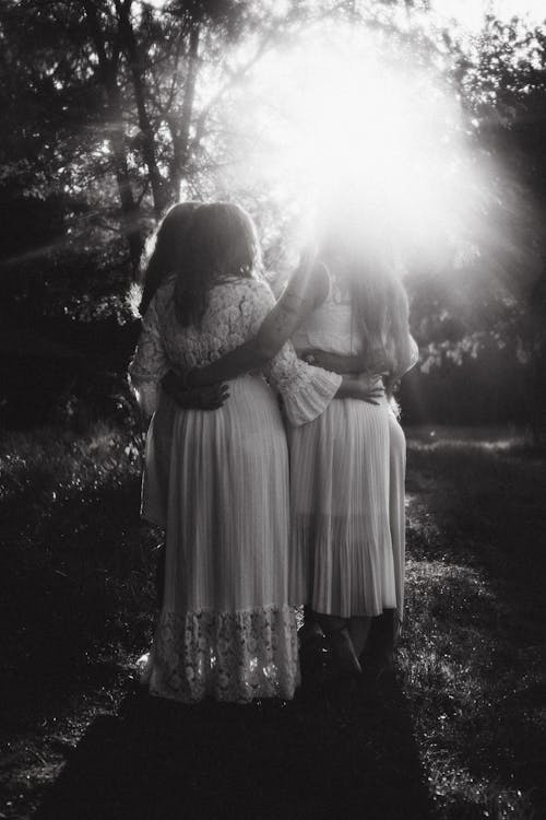 Sunlight over Women in White Dresses in Black and White