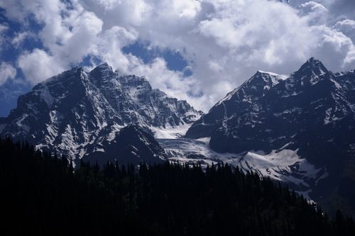 Free Breathtaking view of snow-covered mountains under a cloudy sky in Kashmir. Stock Photo
