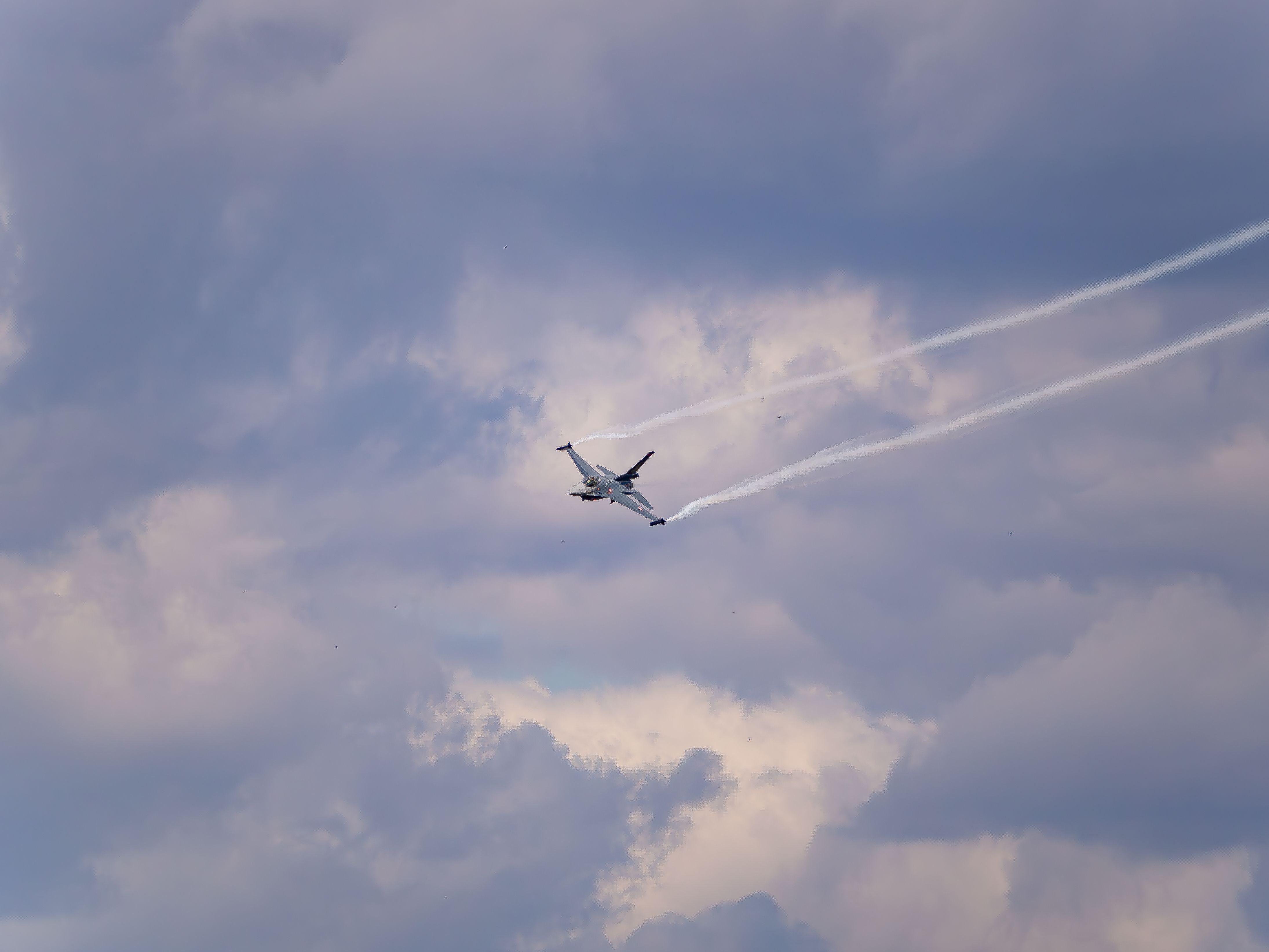 Fighter jet flying under overcast skies