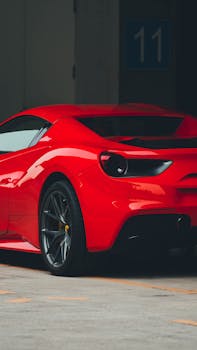 Dynamic rear view of a red sports car parked outdoors, showcasing its aerodynamic design.