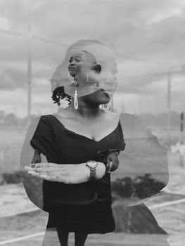 Stylish double exposure in monochrome capturing a woman's pensive expression.