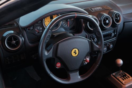 Free Close-up of a Ferrari sports car interior showcasing the dashboard and steering wheel. Stock Photo
