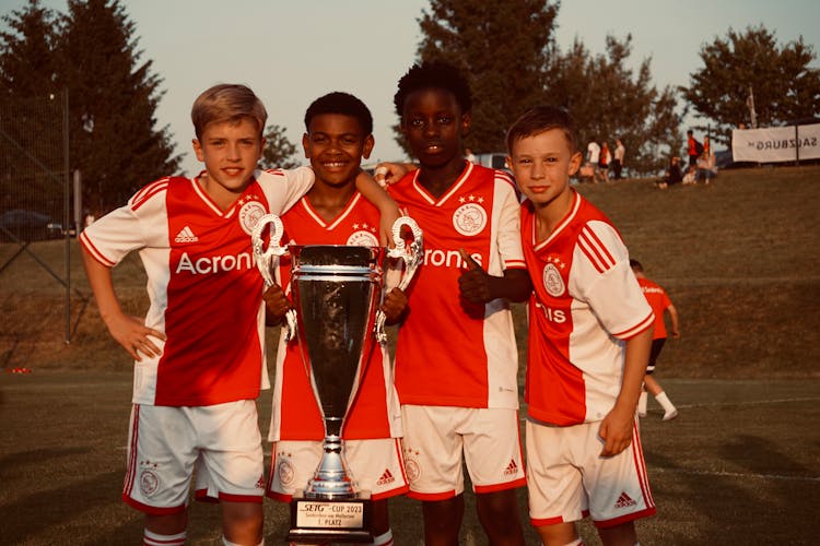 Young Soccer Players Holding Cup