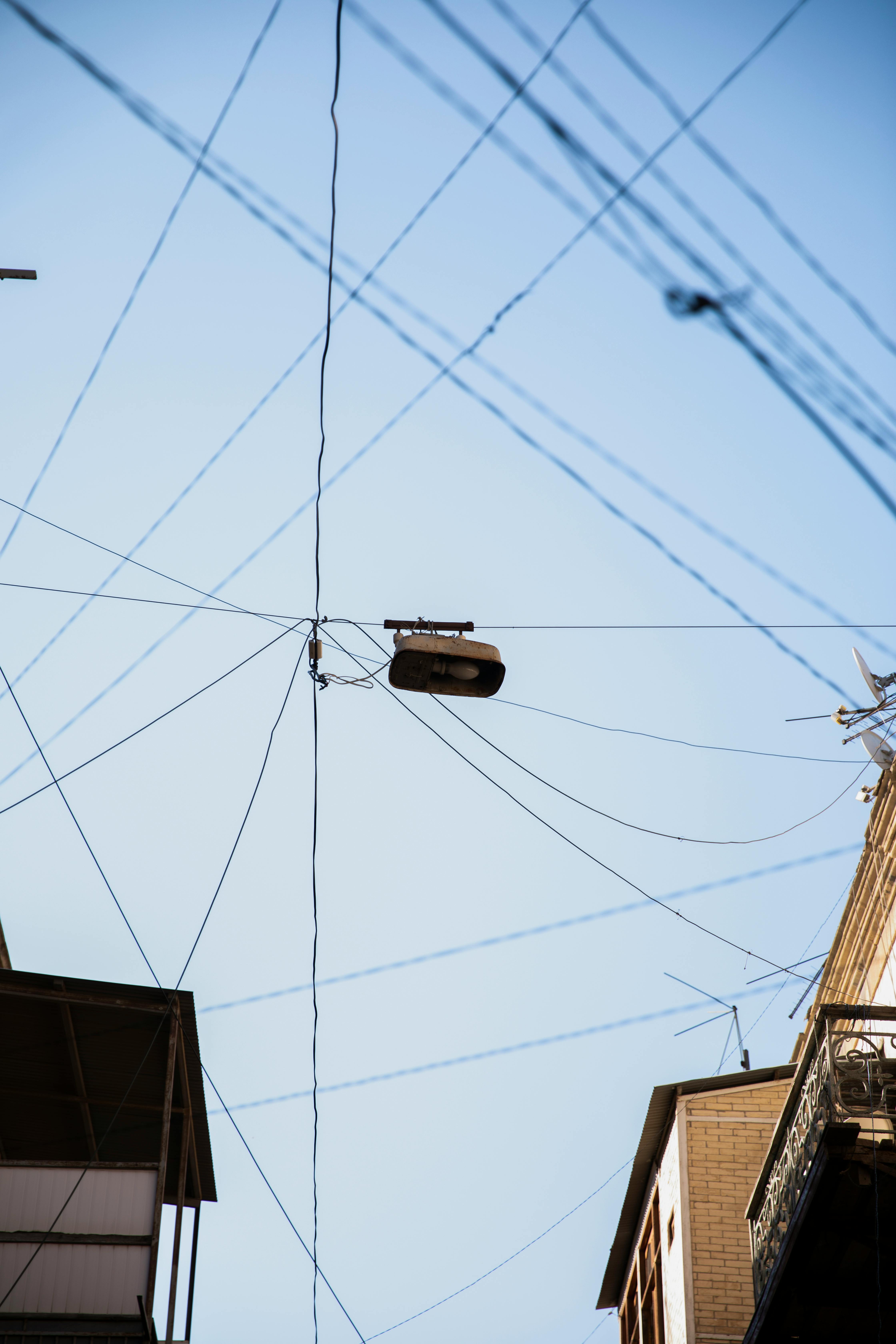 Overhead wires crisscross against clear sky in Baku, showcasing urban infrastructure.