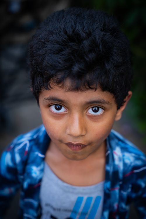 Free A close-up portrait of a young boy with expressive eyes, looking directly at the camera. Stock Photo