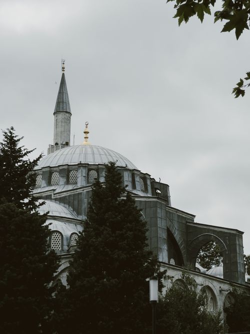 Free A traditional mosque with a minaret in Istanbul, surrounded by trees. Stock Photo