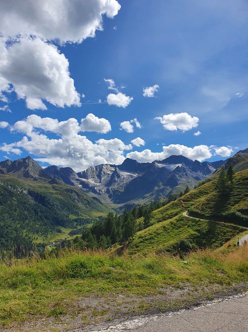 Free Breathtaking view of lush green mountains under a vivid blue sky filled with white clouds. Stock Photo