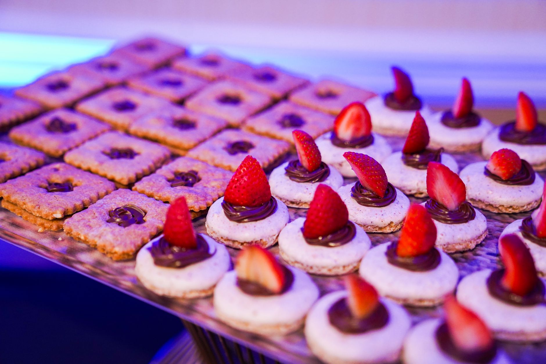 Tempting close-up of chocolate pastries with strawberries on a tray, perfect for dessert lovers.