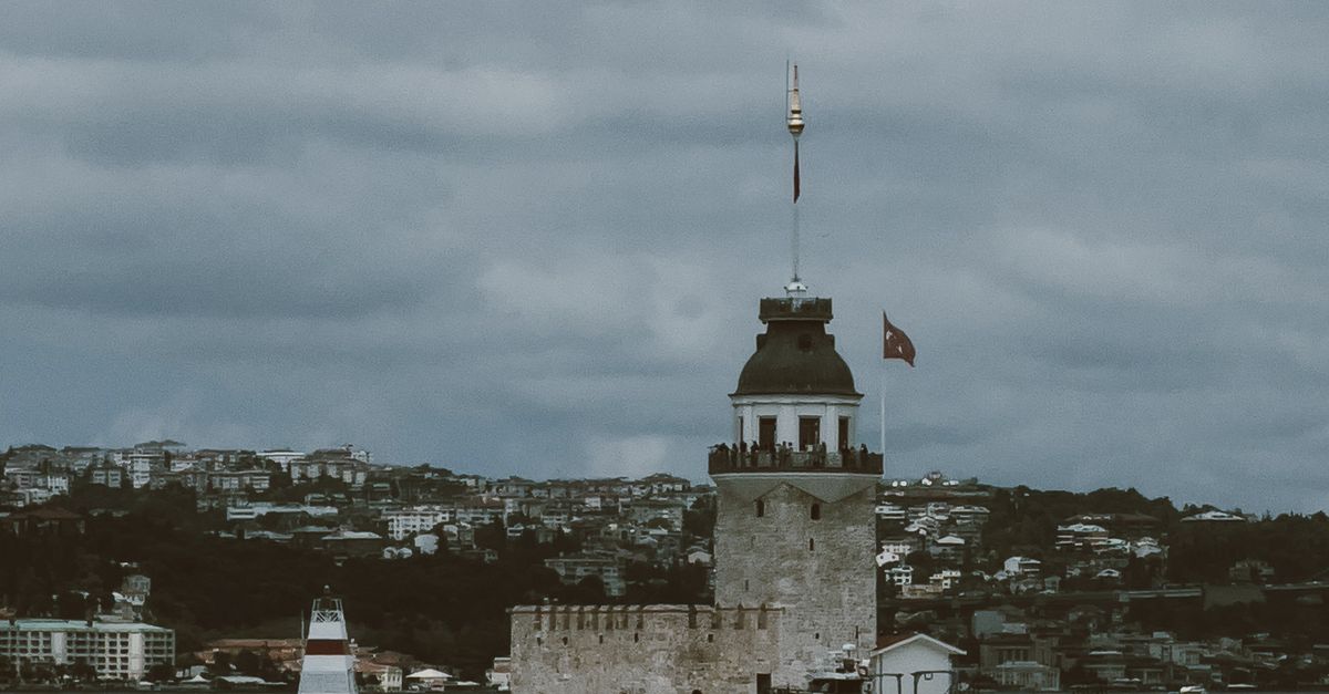 Dramatic view of the historic Maiden's Tower in Istanbul under a cloudy sky.