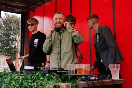 Free DJ and group of teenagers enjoying an open-air music festival, creating a vibrant and lively atmosphere. Stock Photo