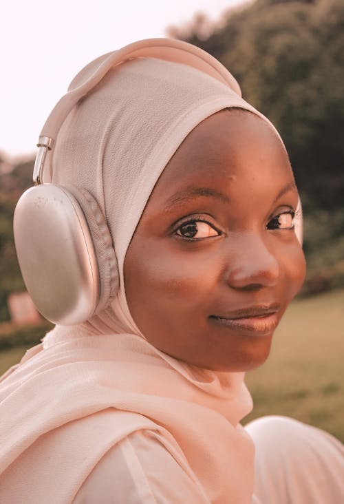 Young Woman in a White Headscarf and Headphones