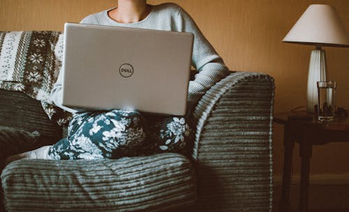 Free Person Using Dell Laptop While Sitting On Sofa Inside Room Stock Photo