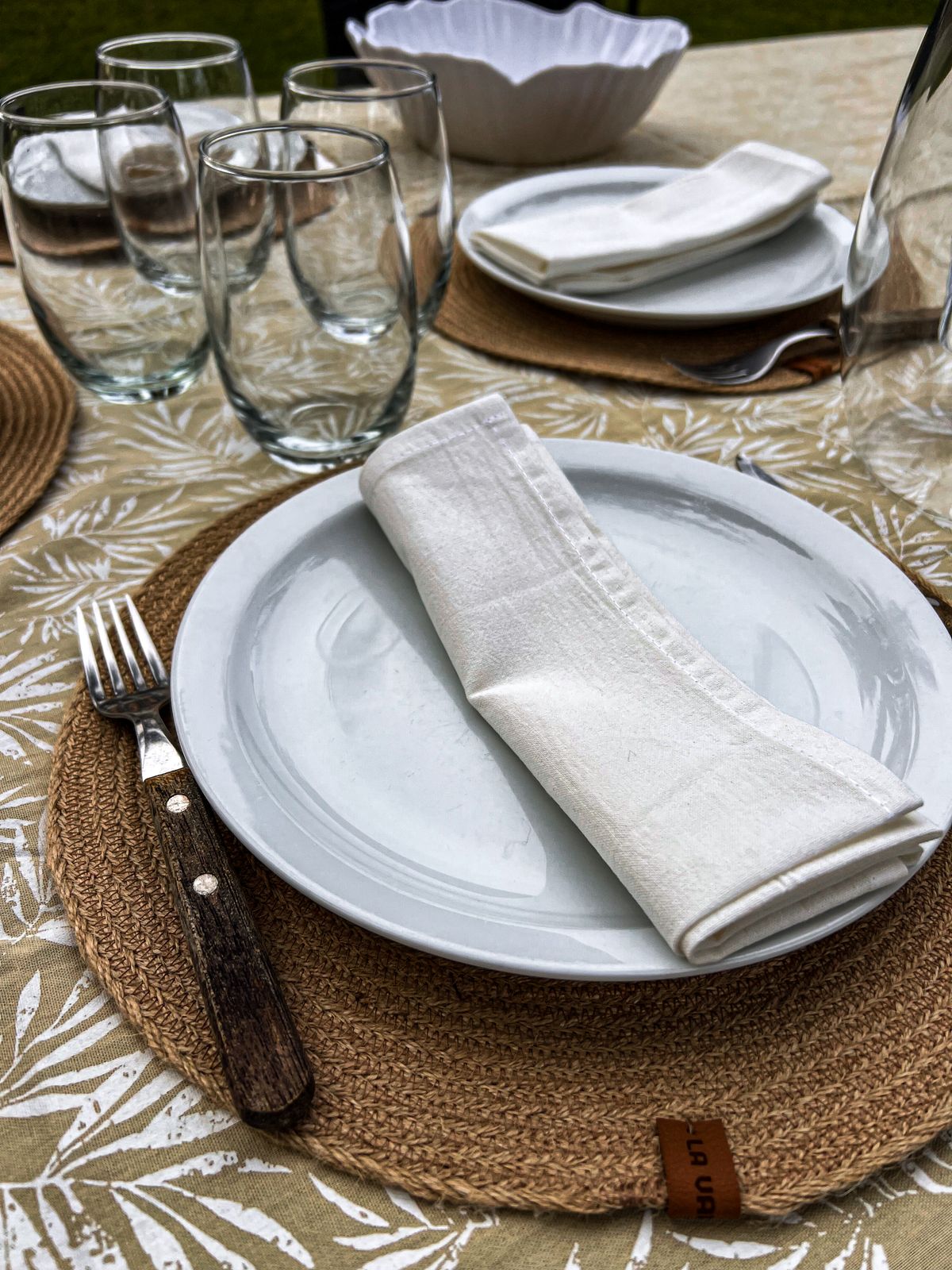 A long table with linen napkins and fine dinnerware, the light low.