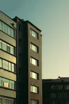 Vertical shot of a city apartment building exterior during sunset.