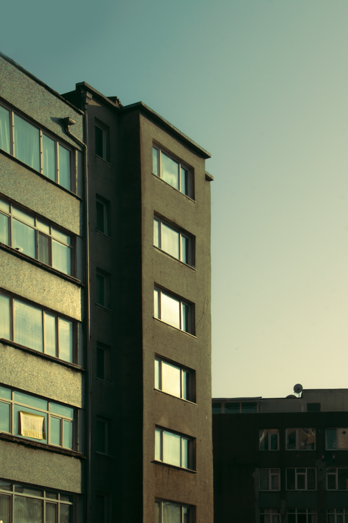 Free Vertical shot of a city apartment building exterior during sunset. Stock Photo