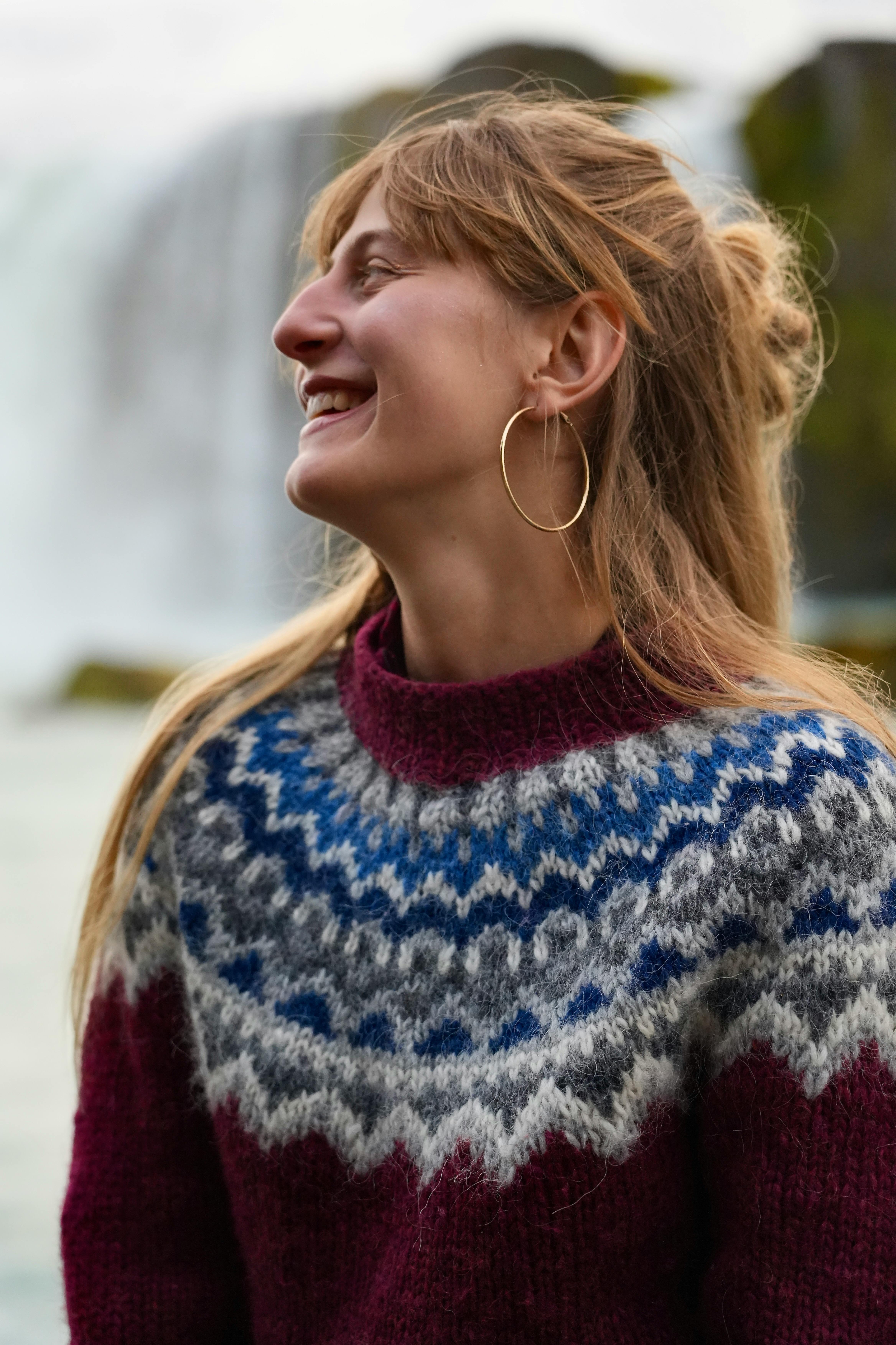 a woman smiling in front of a waterfall