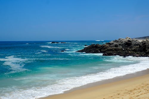 View of a Rocky Coast under Blue Sky 