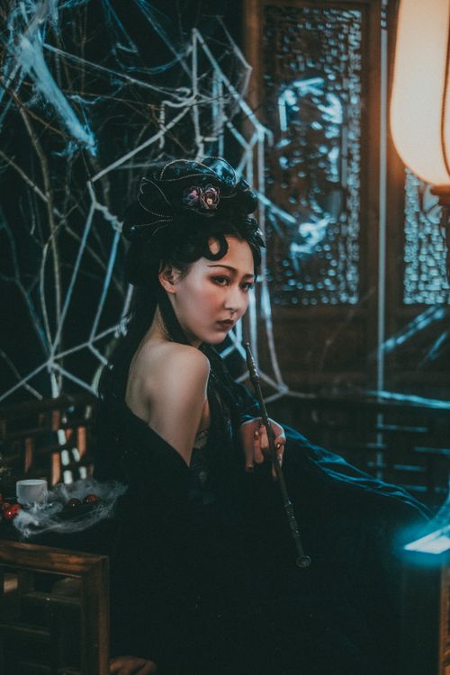 Free Portrait of a woman in a gothic Halloween setting with cobwebs and moody lighting. Stock Photo