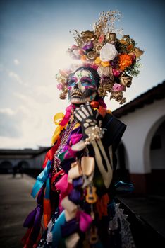 Close-up portrait of a woman in colorful Dia de los Muertos costume and skull makeup.