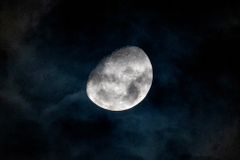 A captivating view of the gibbous moon shining through dark clouds in the night sky over Rio de Janeiro.