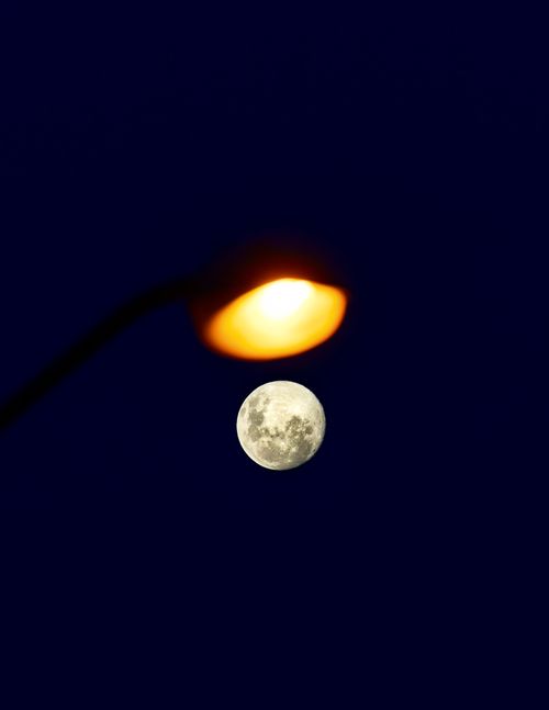 Free Captivating view of a full moon beside a glowing streetlamp in Rio de Janeiro. Stock Photo