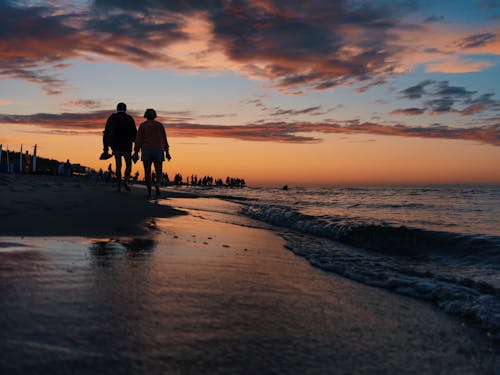 People Walking on a Beach During Sunset