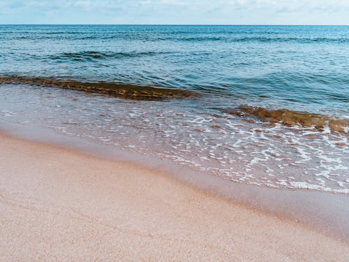 Free Beach Washed by the Waters of the Ocean Stock Photo