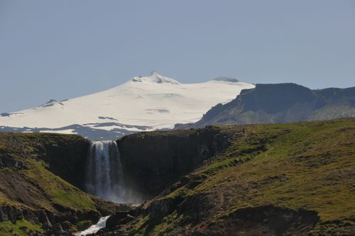 Free Svödufoss waterfall cascading with icy backdrop, capturing Iceland's pristine nature. Stock Photo