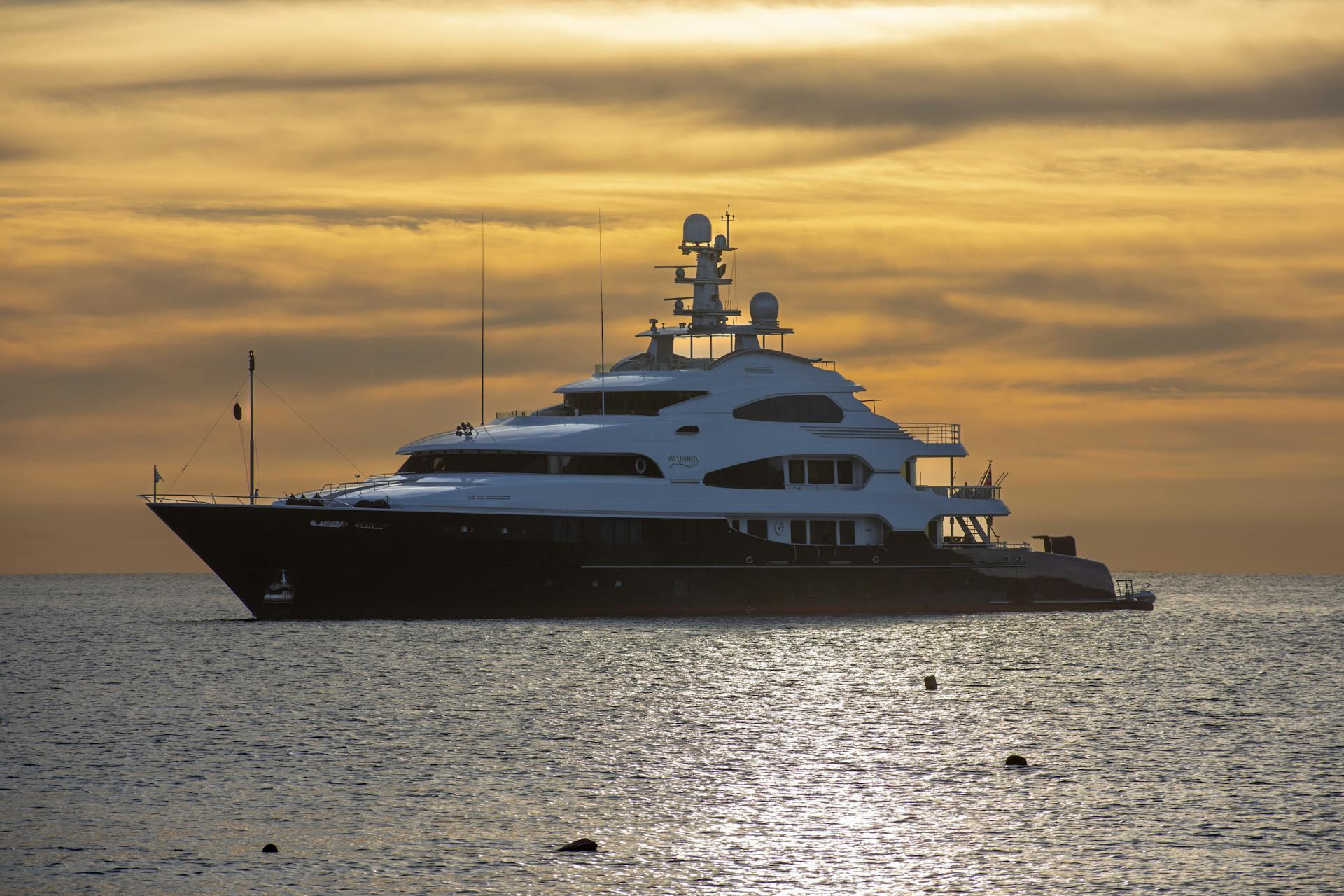 Stunning view of a luxury yacht sailing at sunset in Cabo San Lucas, Mexico's tranquil waters.
