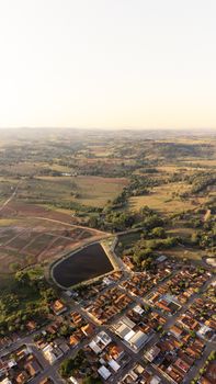 Drone shot capturing farmland and townscape in Guaraíta, Brazil at dusk.