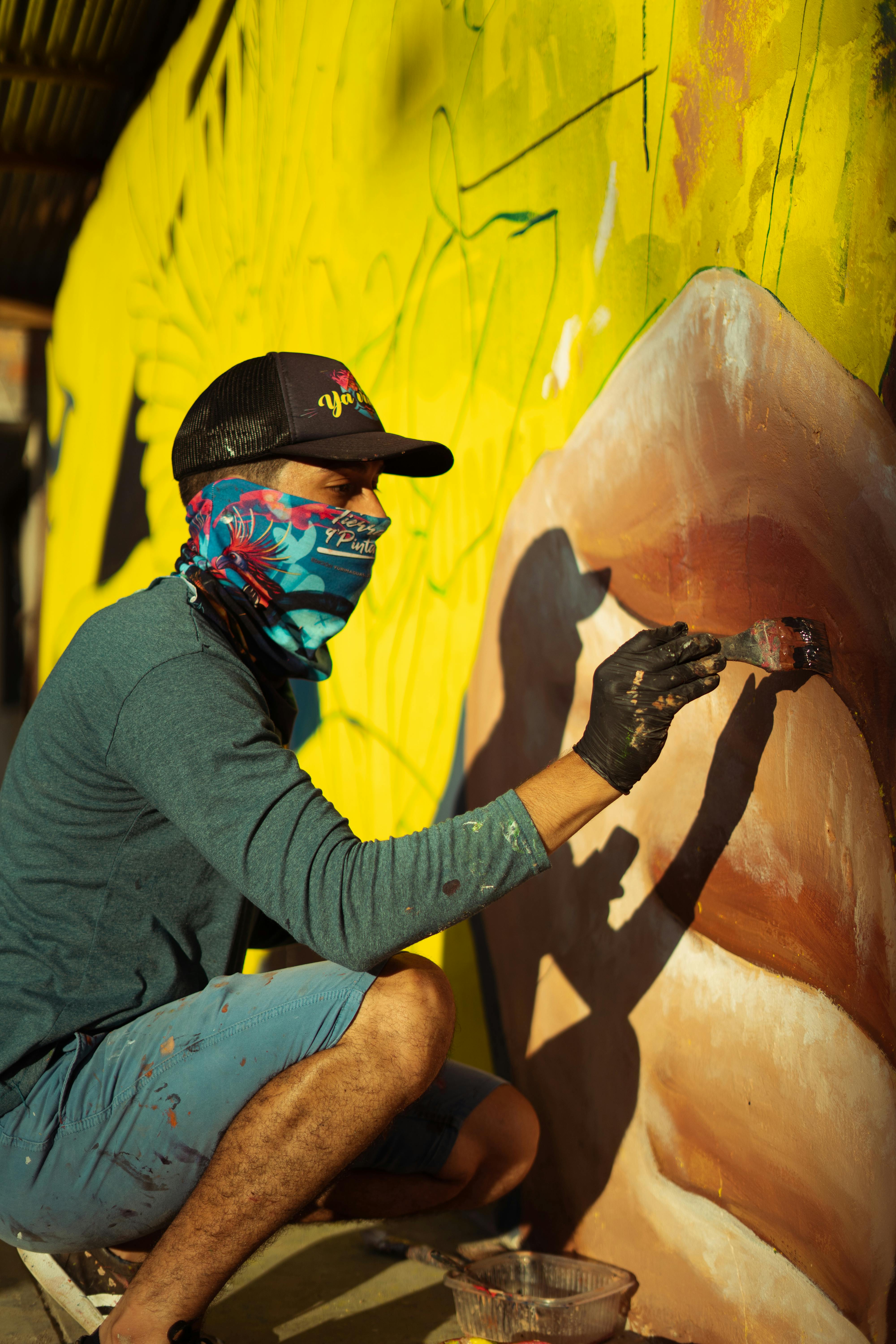 Artist painting a vivid mural on an outdoor wall in Moyobamba, Peru.